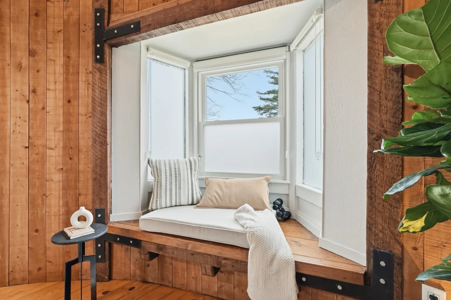 The Silo’s cushioned window seat framed by warm timber walls and tall windows.